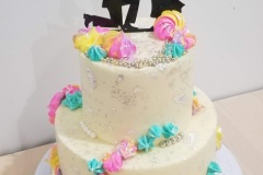 Two Tiers of Carrot Cake. Filled and Covered with Cream Cheese Frosting. Decorated with some Meringue Cookies.