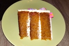 Two Tiers of Carrot Cake. Filled and Covered with Cream Cheese Frosting. Decorated with some Meringue Cookies.